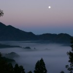 谷を埋める朝霧と満月